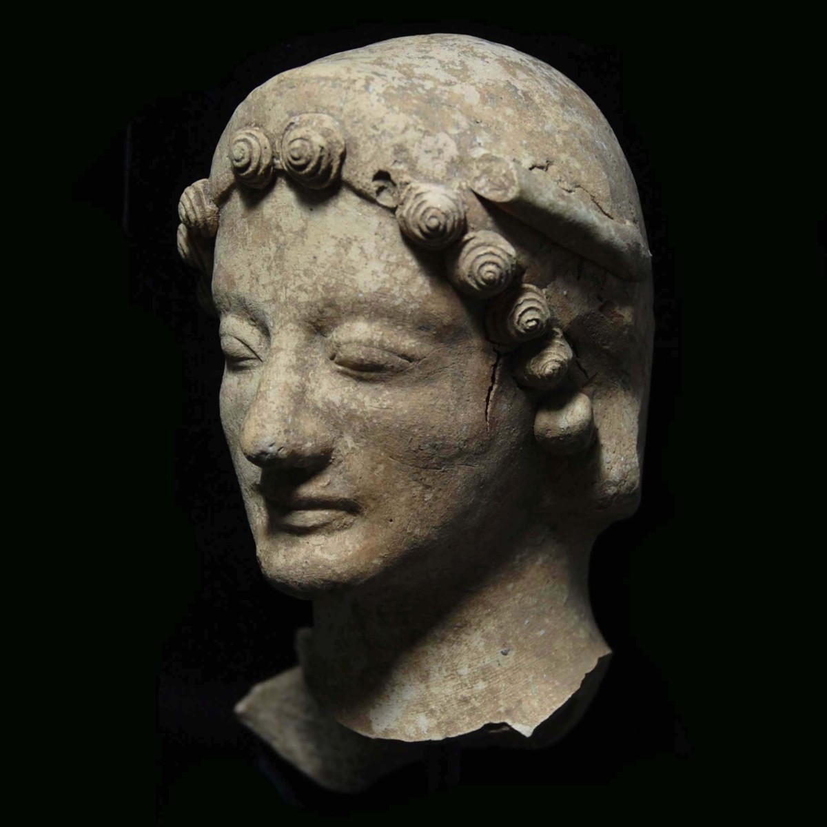Greek archaic terracotta head of a goddess half left