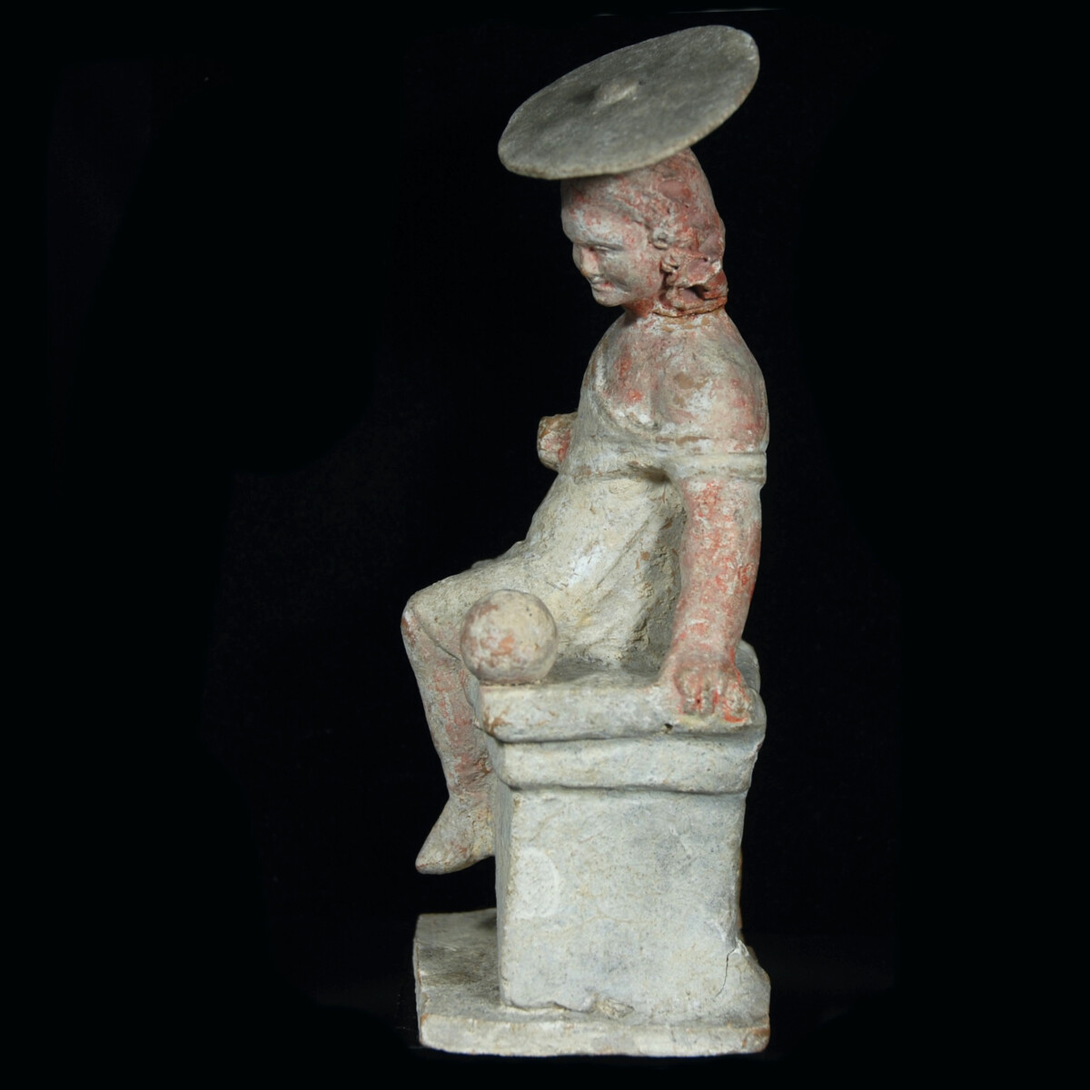 Hellenistic Tanagra statuette of a girl with sun hat left